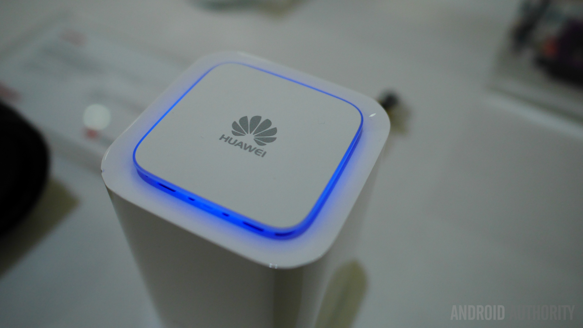 The Huawei logo surrounded by a blue light. 