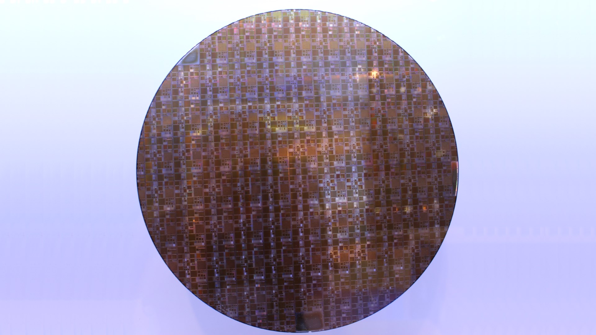 A circular silicon wafer etched with various circuits and chips