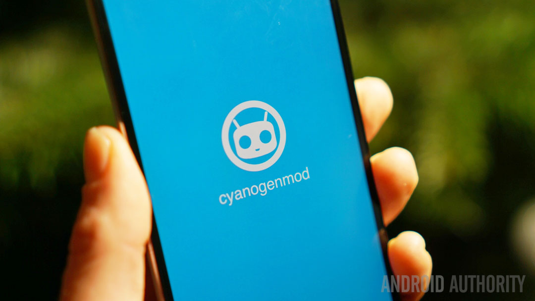 Phone in hand showing CyanogenMod splash screen.