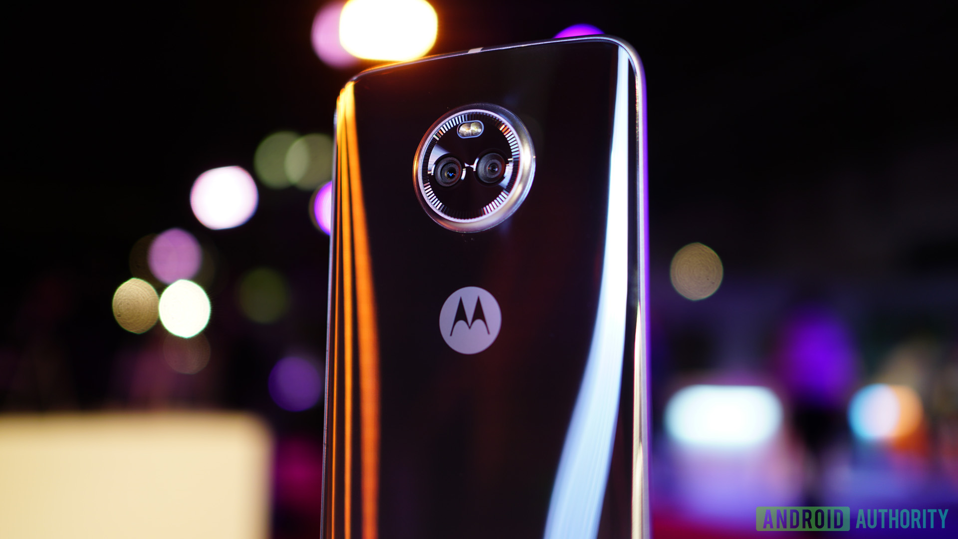 The Moto X4 from behind with out of focus lights in the background. 