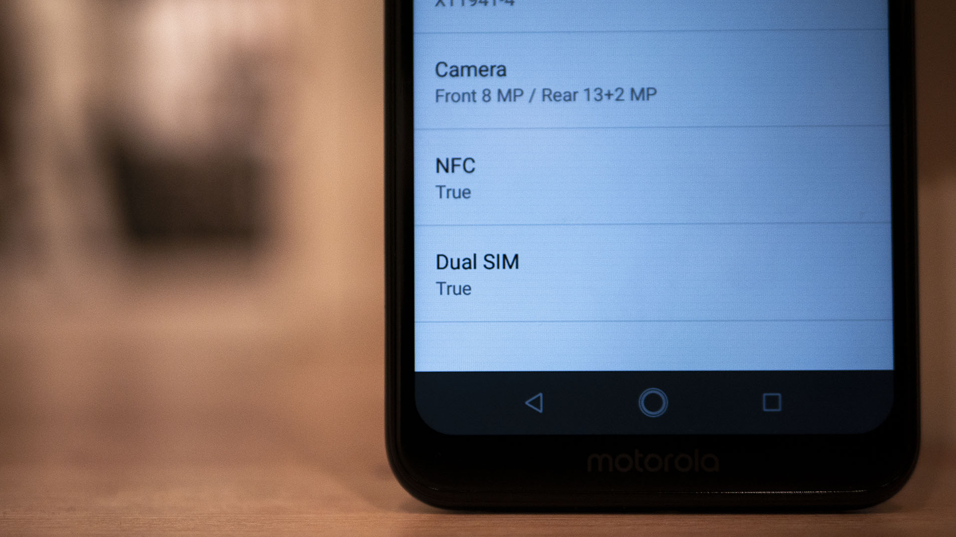 A photo of NFC, Dual SIM, and Camera settings on a Moto One