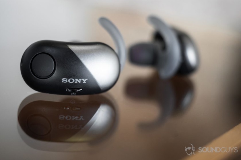 Sony WF-SP700N true wireless earbuds on glass surface.