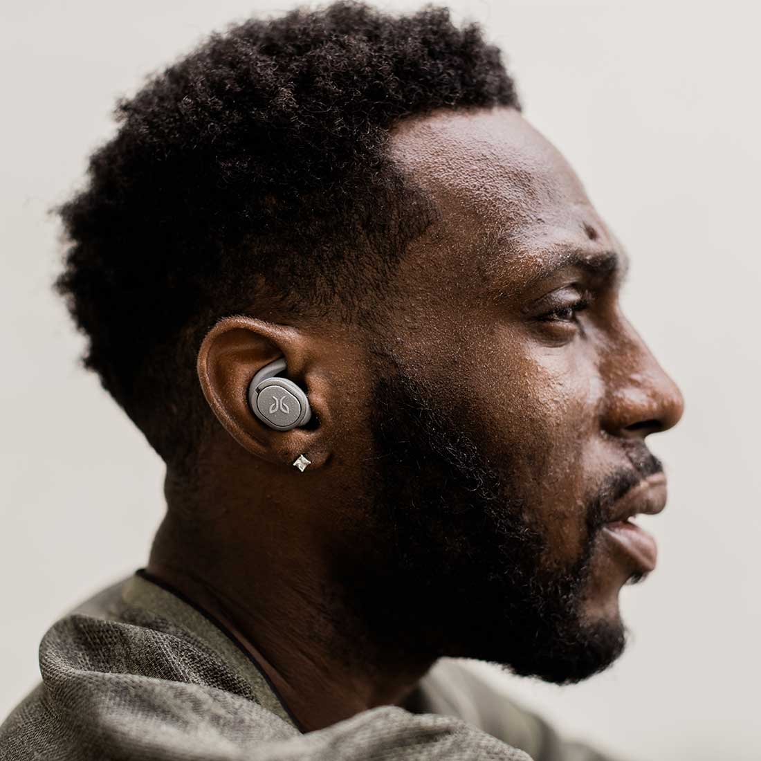 Jaybird lifestyle image. The profile of a man wearing the earbuds in storm-gray.
