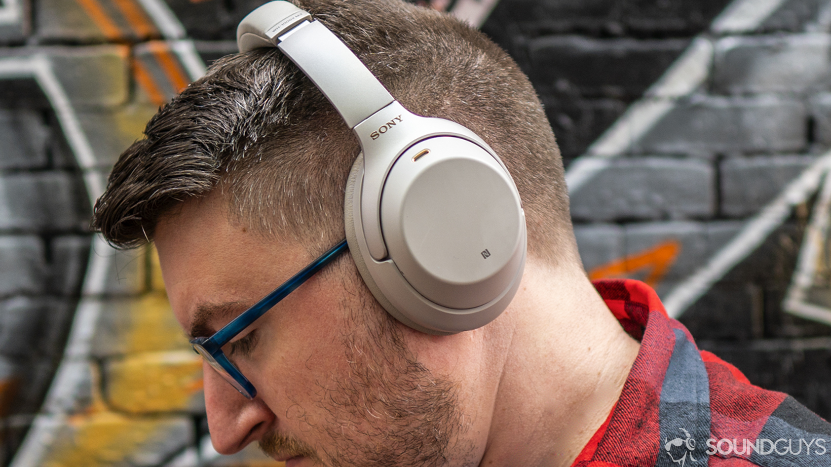 A photo of a man wearing wireless headphones.