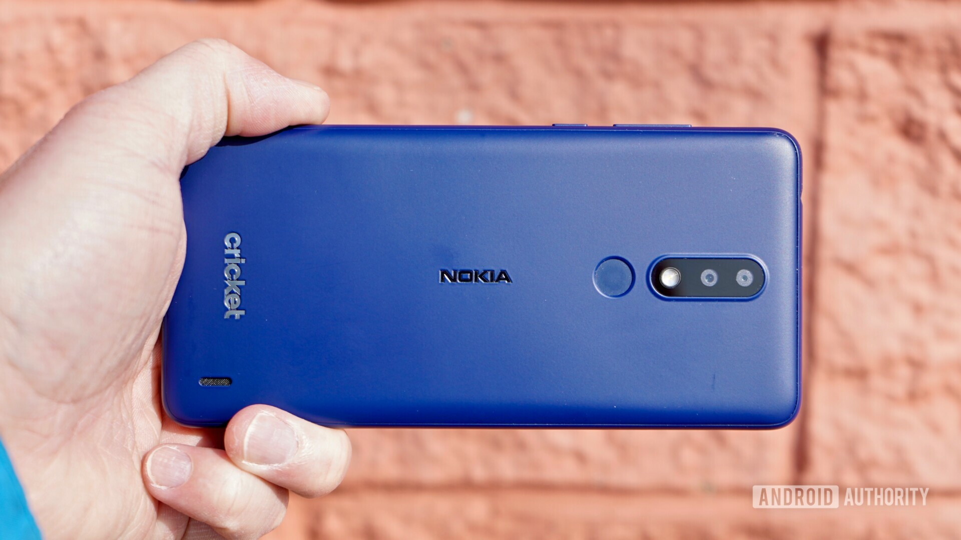 Horizontal back side view of the Blue Nokia 3.1 Plus held in a hand.