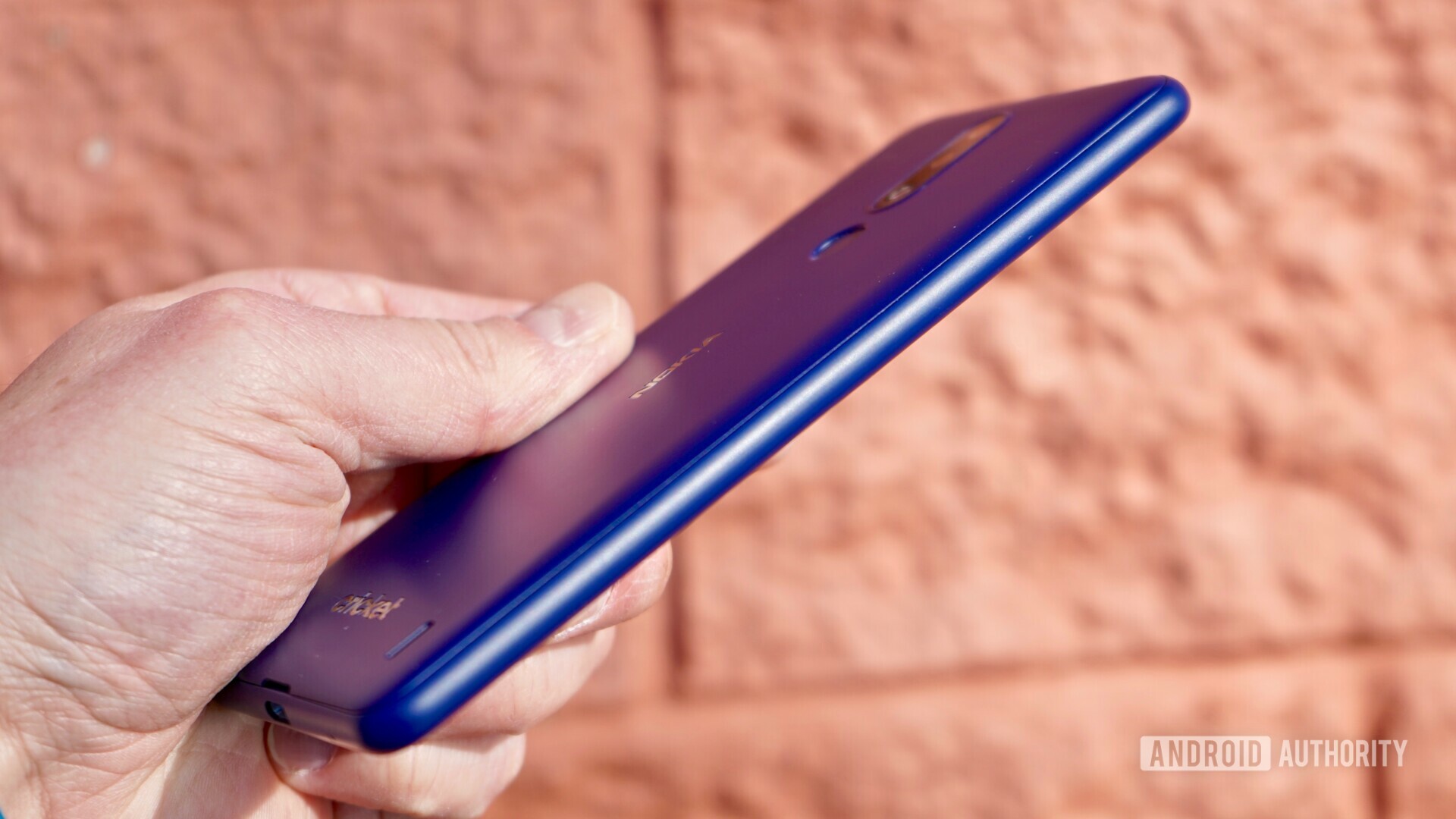 Right side view of the Blue Nokia 3.1 Plus held in a hand.
