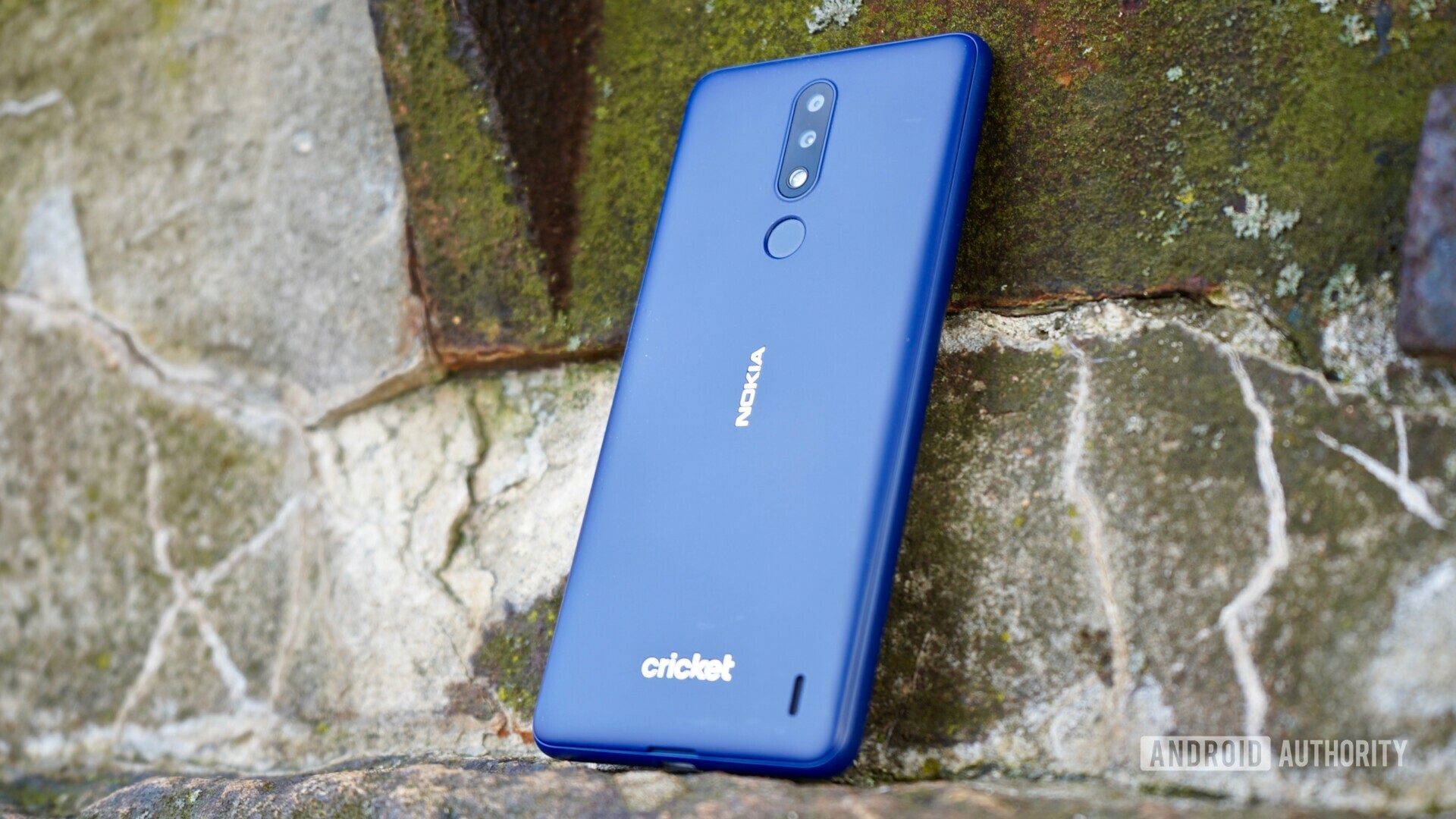 Back side view of the Blue Nokia 3.1 Plus on a stone.