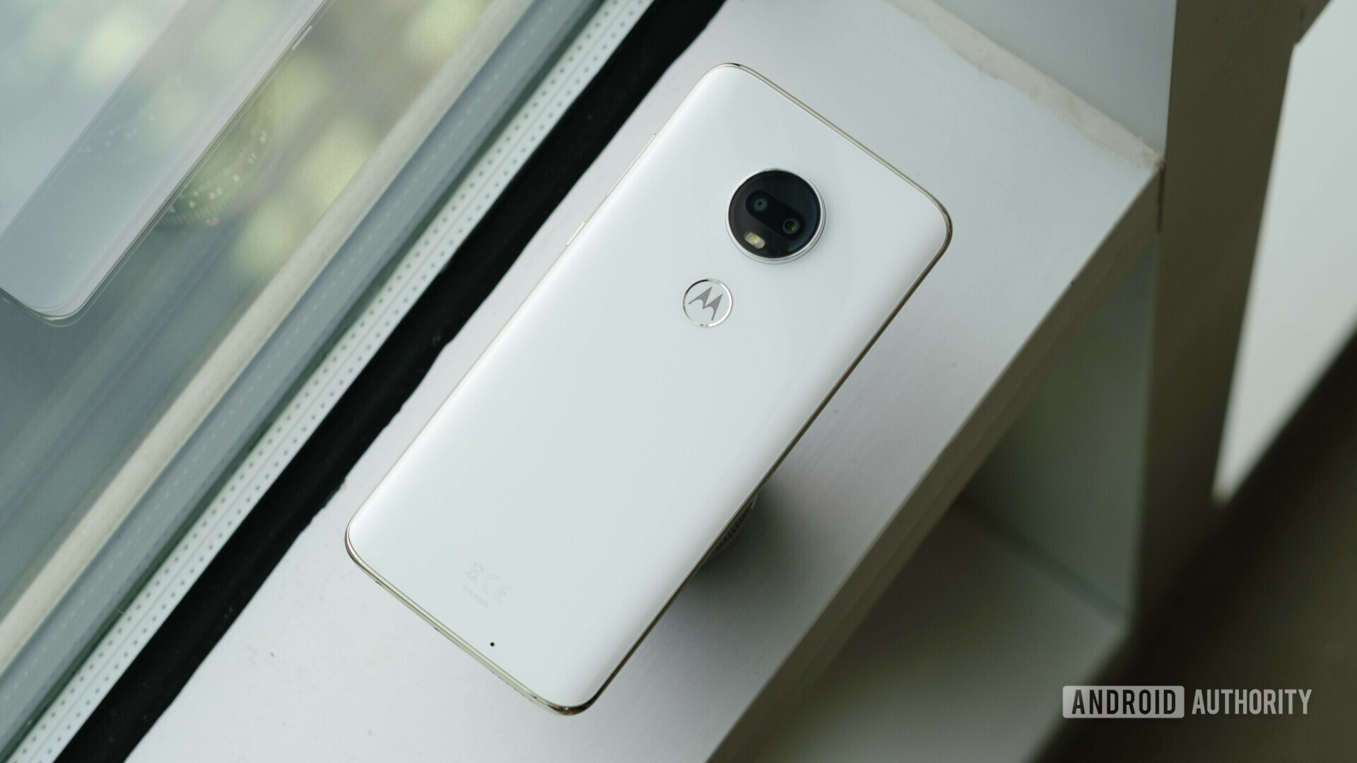 The Moto G7 in white on a window ledge.