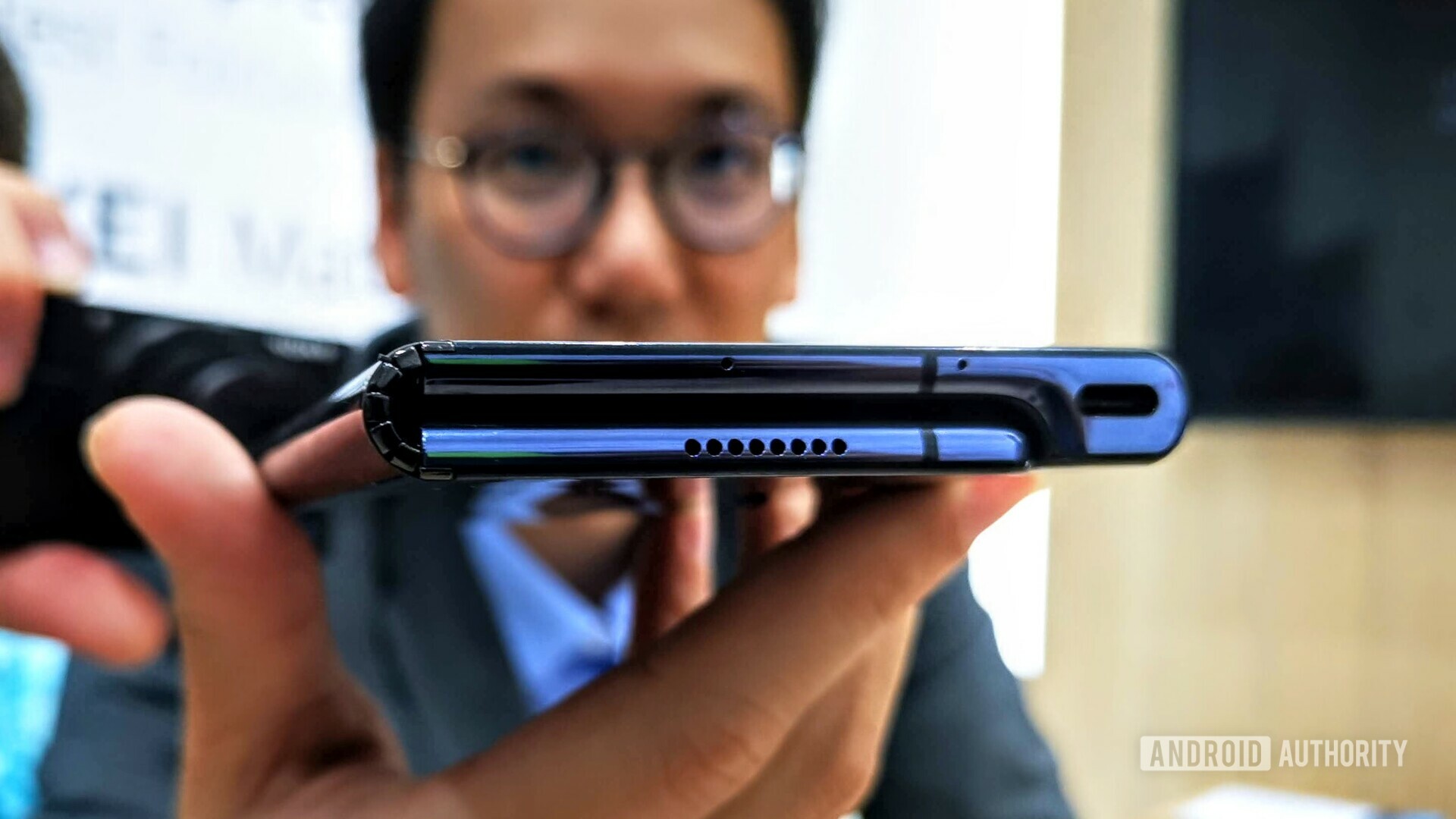 The Huawei Mate X folded in a person's hand.