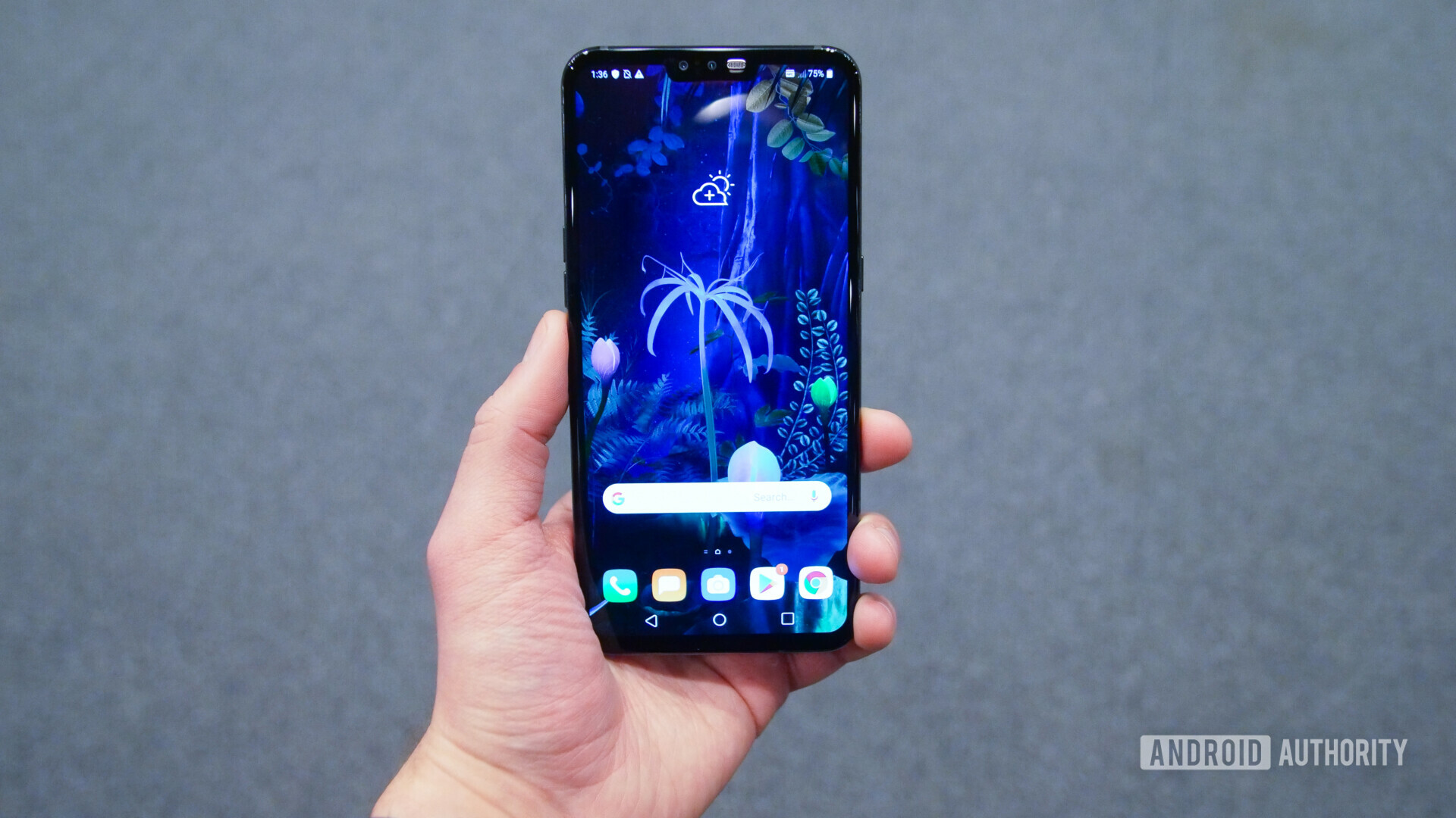 Front view of the LG V50 ThinQ with a display turned on, held in a hand.