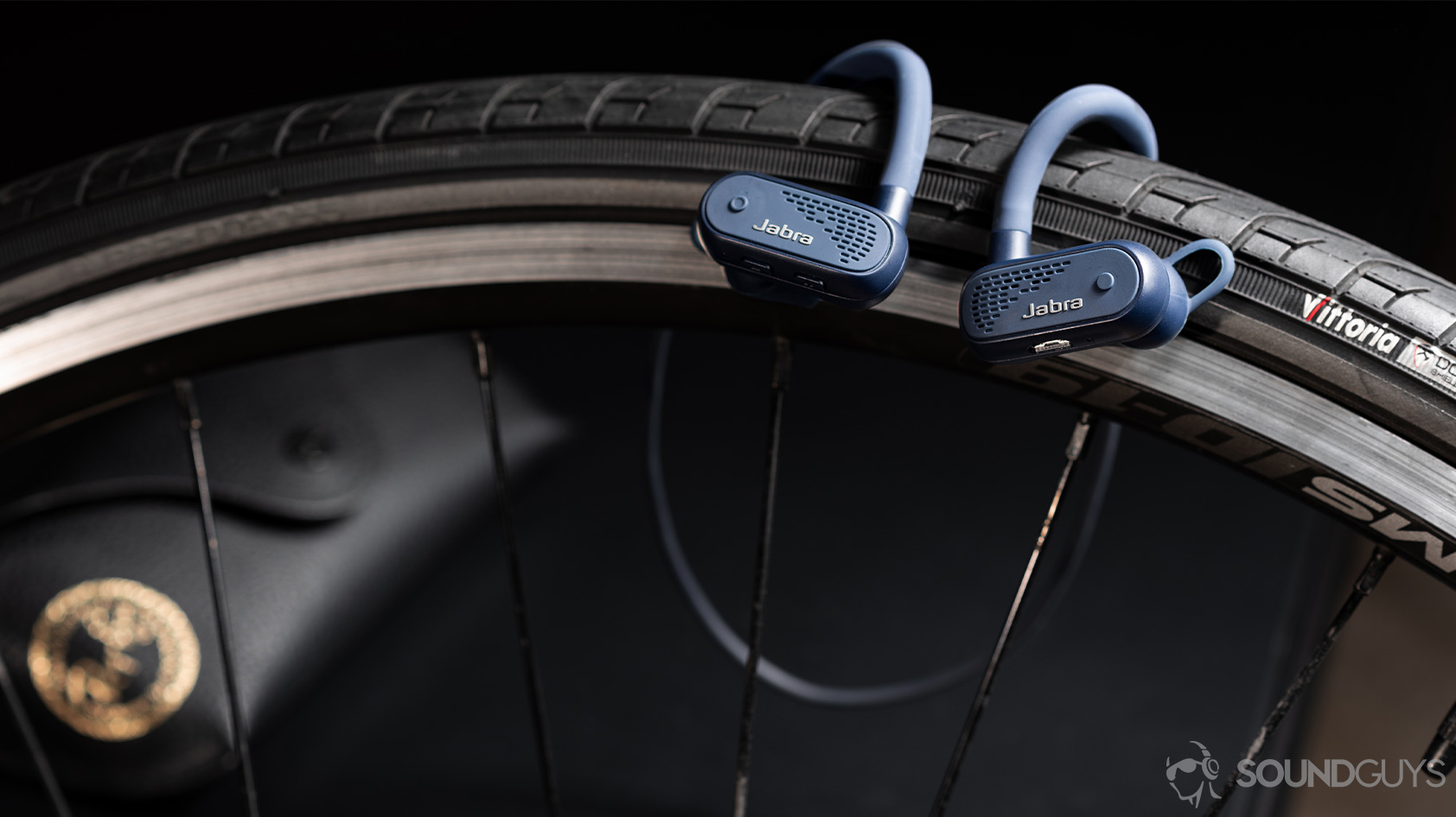 The Jabra Elite Active 45e earbuds hanging on a road bike tire.