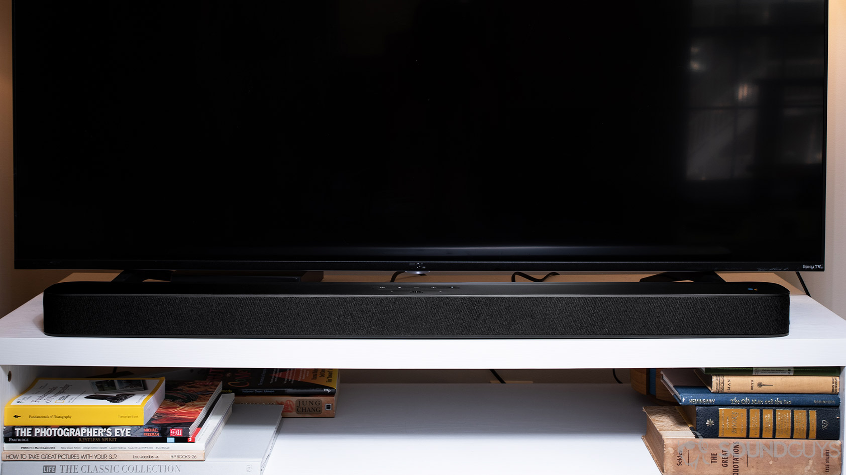 The JBL Link Bar review image of it resting directly beneath a TLC smart TV.