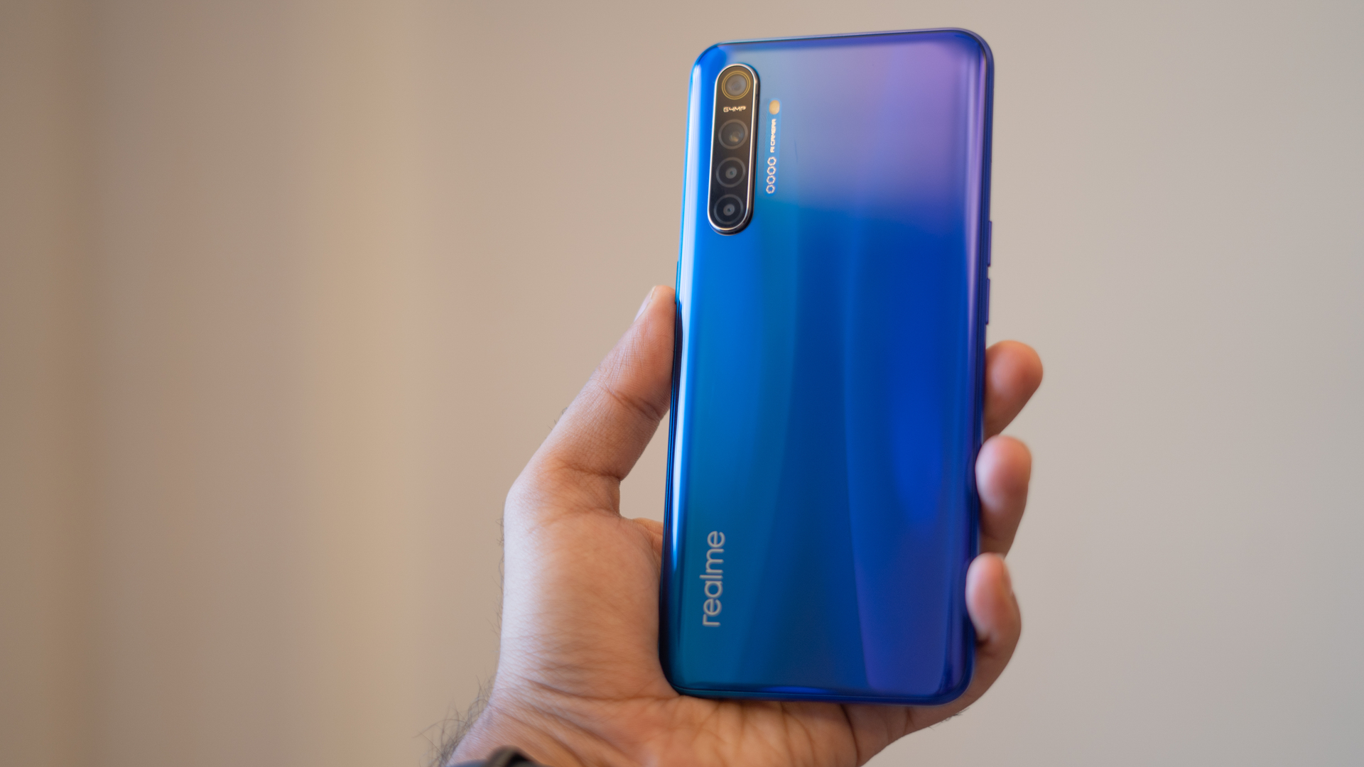 Realme XT in hand with back panel and gradient