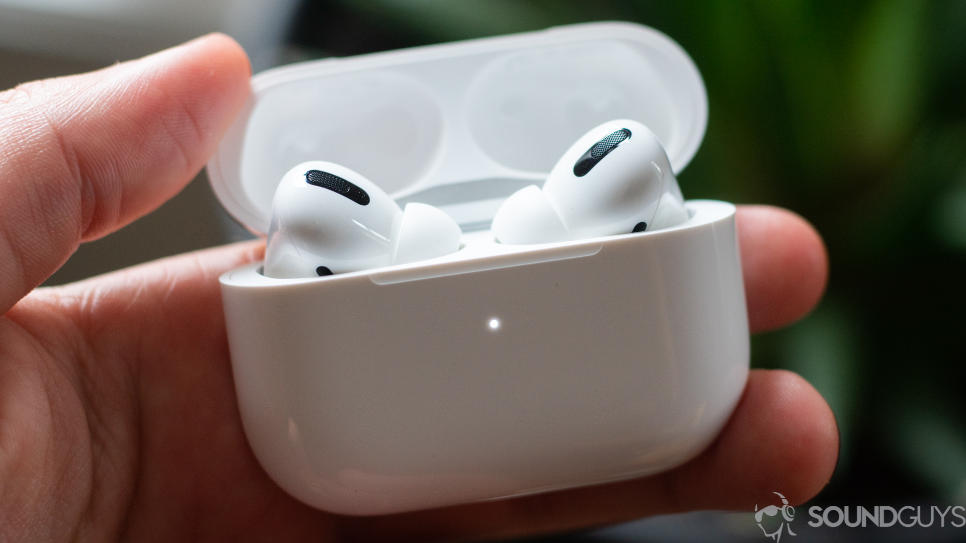 A picture of the Apple AirPods Pro earbuds charging case in a man's hand.
