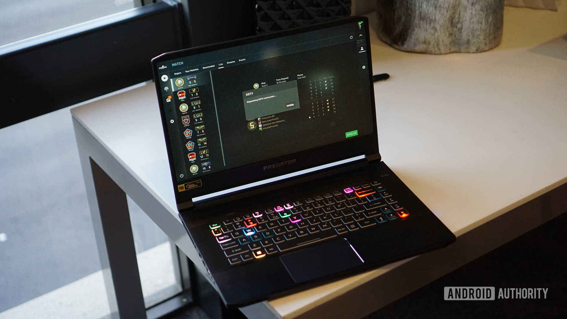 The Acer Predator laptop on the desktop turns on and displays an RGB backlit keyboard.