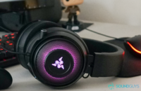 The Razer Kraken Ultimate lays in front of computer monitor and keyboard, as well as an oculus quest and a han solo doll.