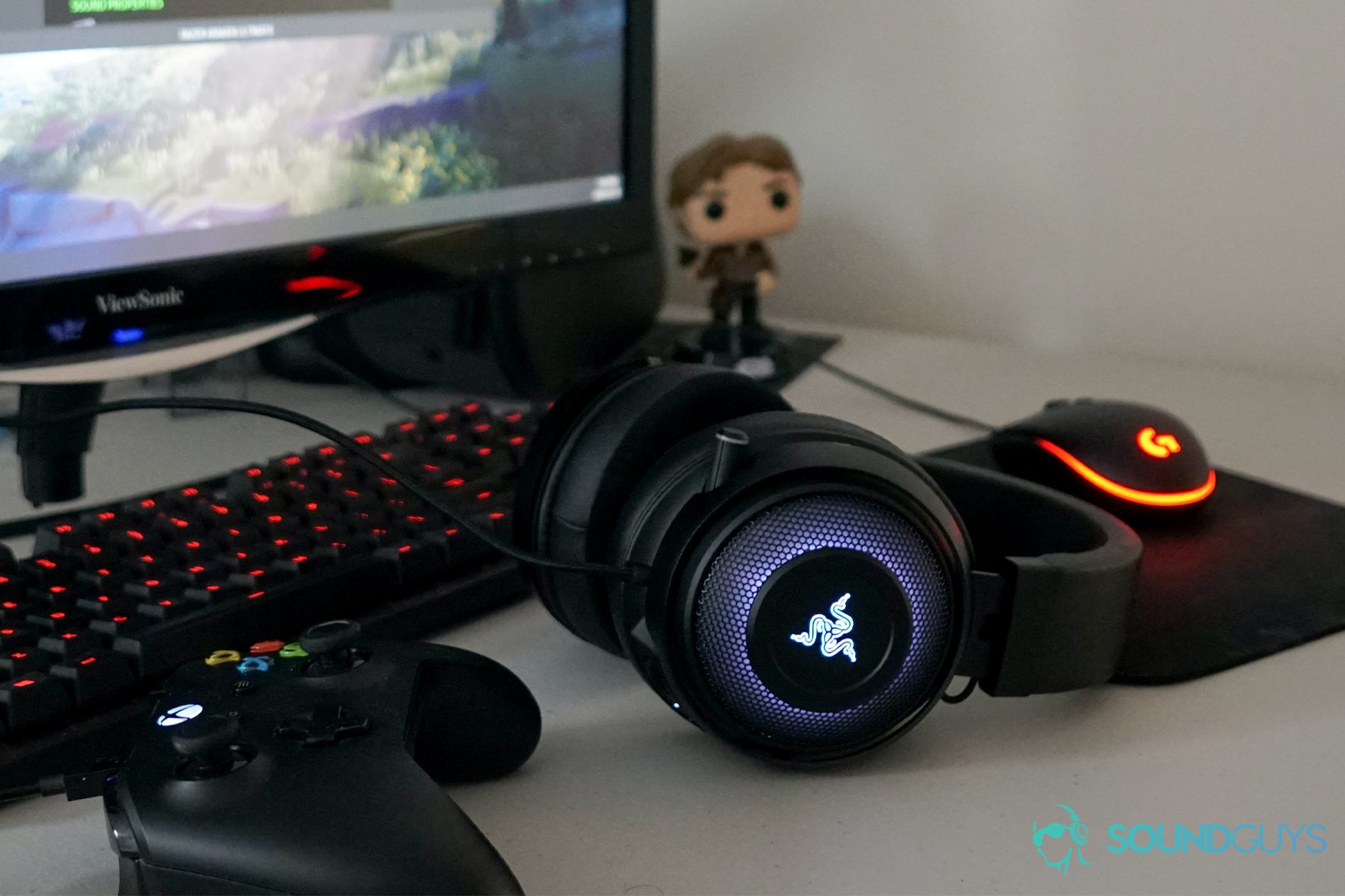 The Razer Kraken Ultimate sits on a desk in front of a PC, monitor, mouse, and keyboard, next to an Xbox One controller in front of a Han Solo doll.