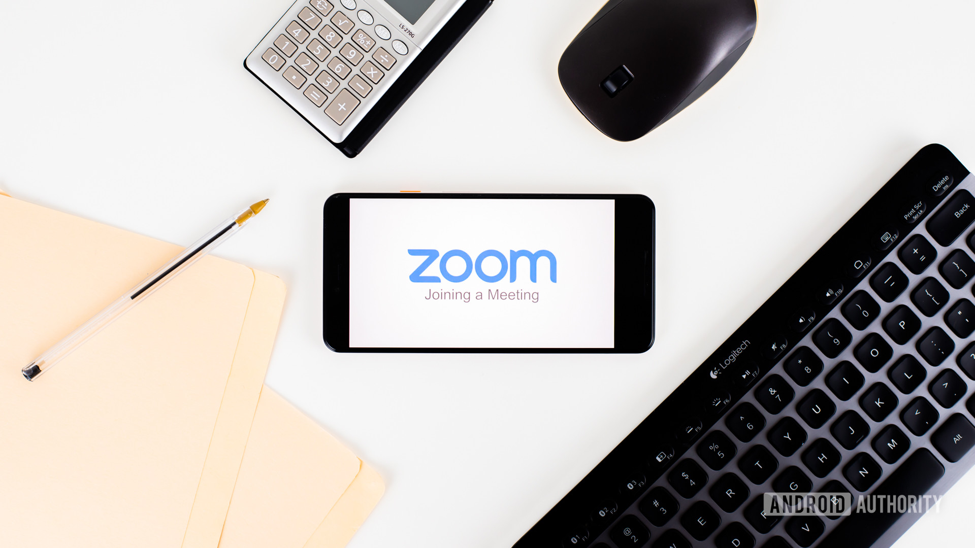 Zoom Meetings on smartphone next to office equipment stock 1 - Zoom vs Skype
