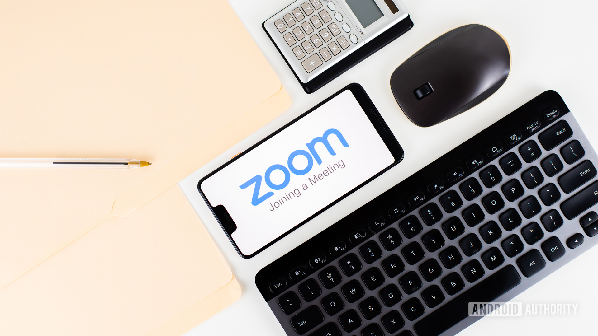 Zoom Meetings on smartphone next to office equipment stock 2 - Zoom vs Skype