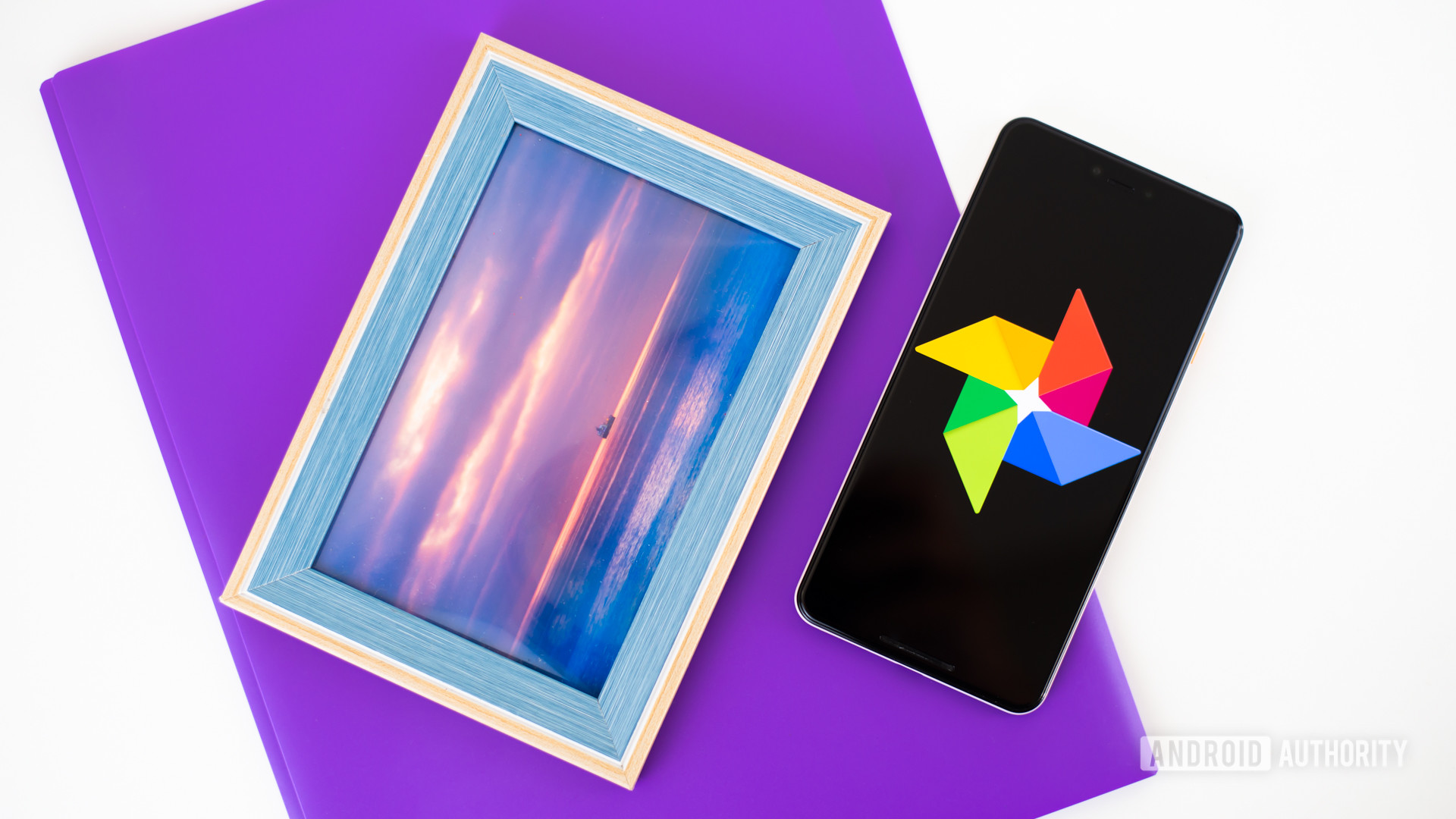 Google Photos logo on smartphone next to imaging accessories stock photo 2