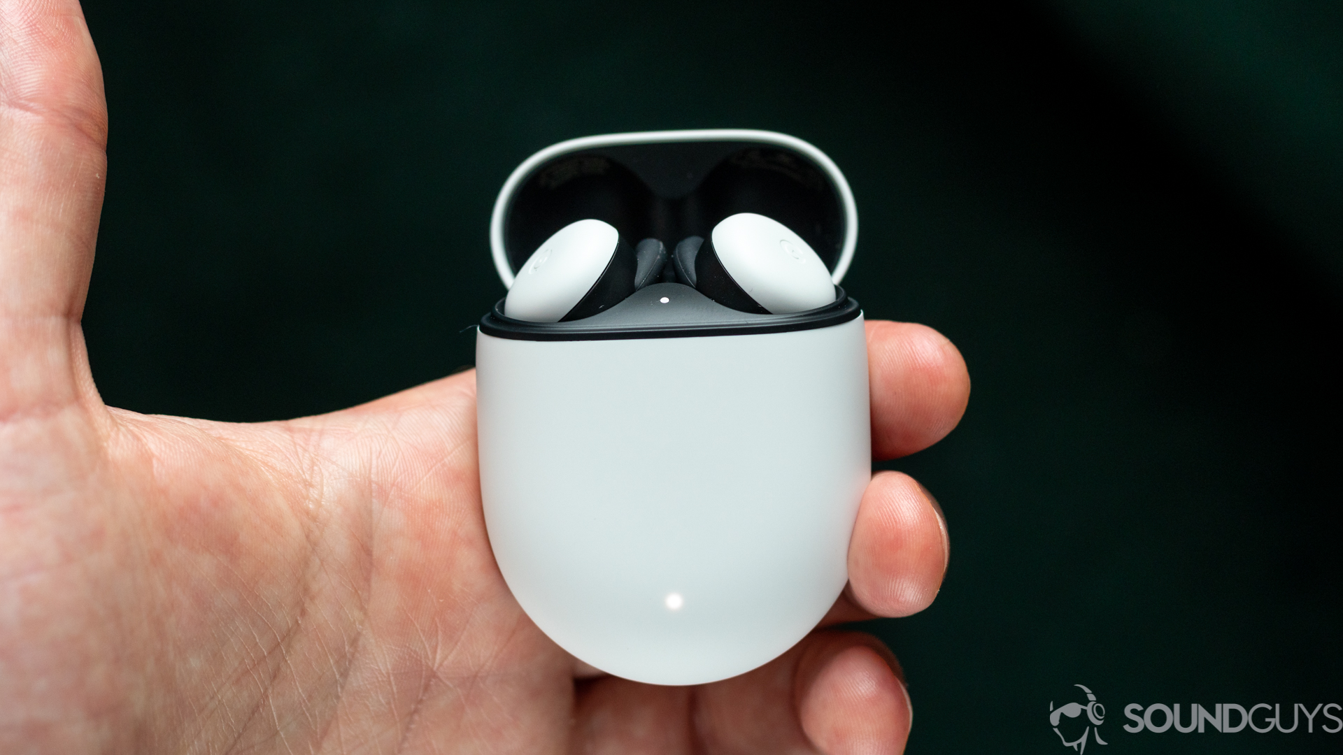 A hand holds the Google Pixel Buds 2020 true wireless earbuds case open to reveal the earbud.