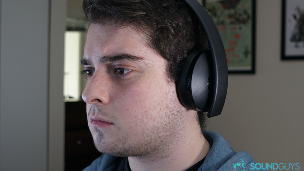A man seated wearing the Playstation Gold Wireless Headset.