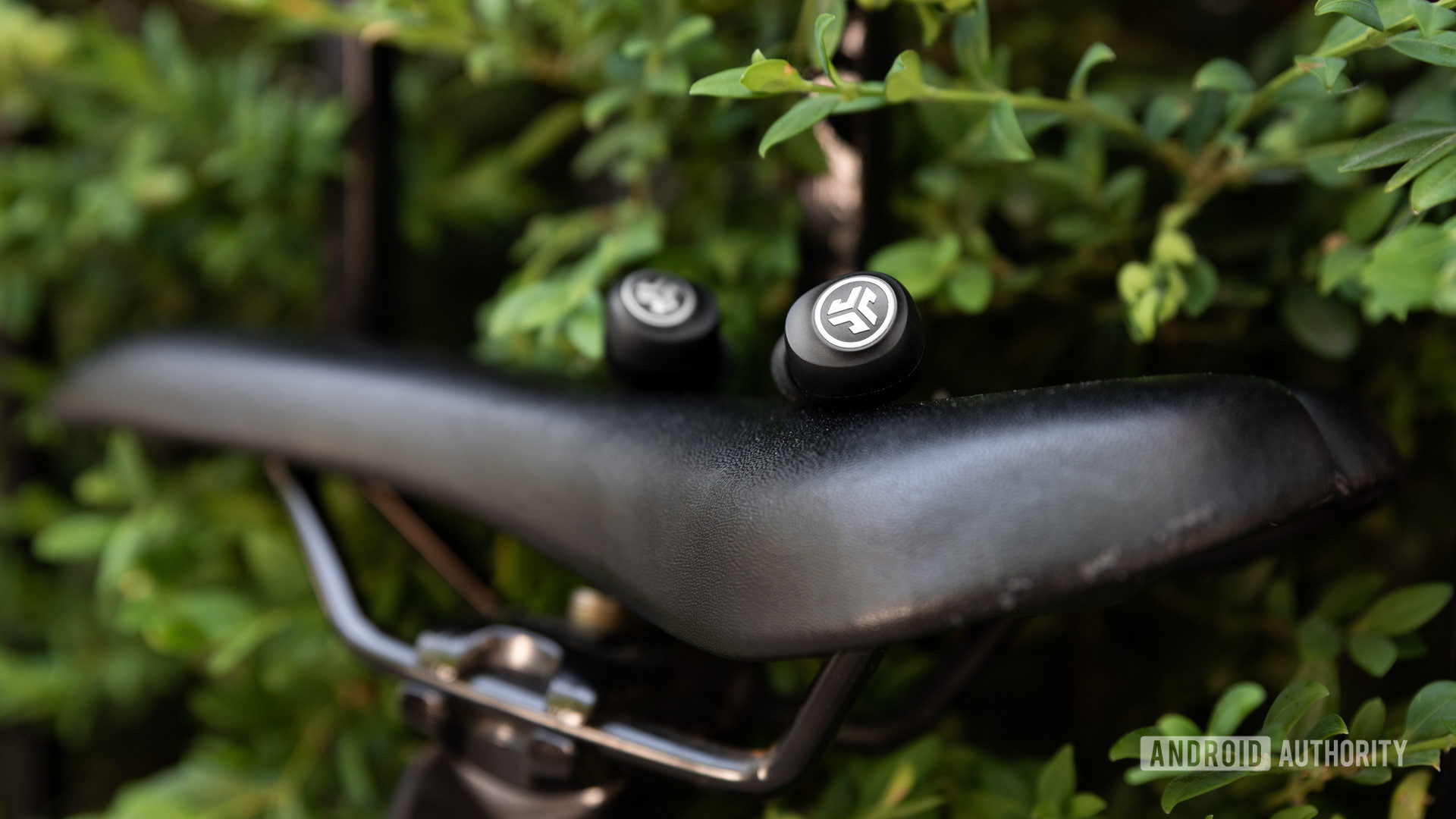 A photo of the JLab GO Air cheap true wireless earbuds sitting atop a bike saddle.
