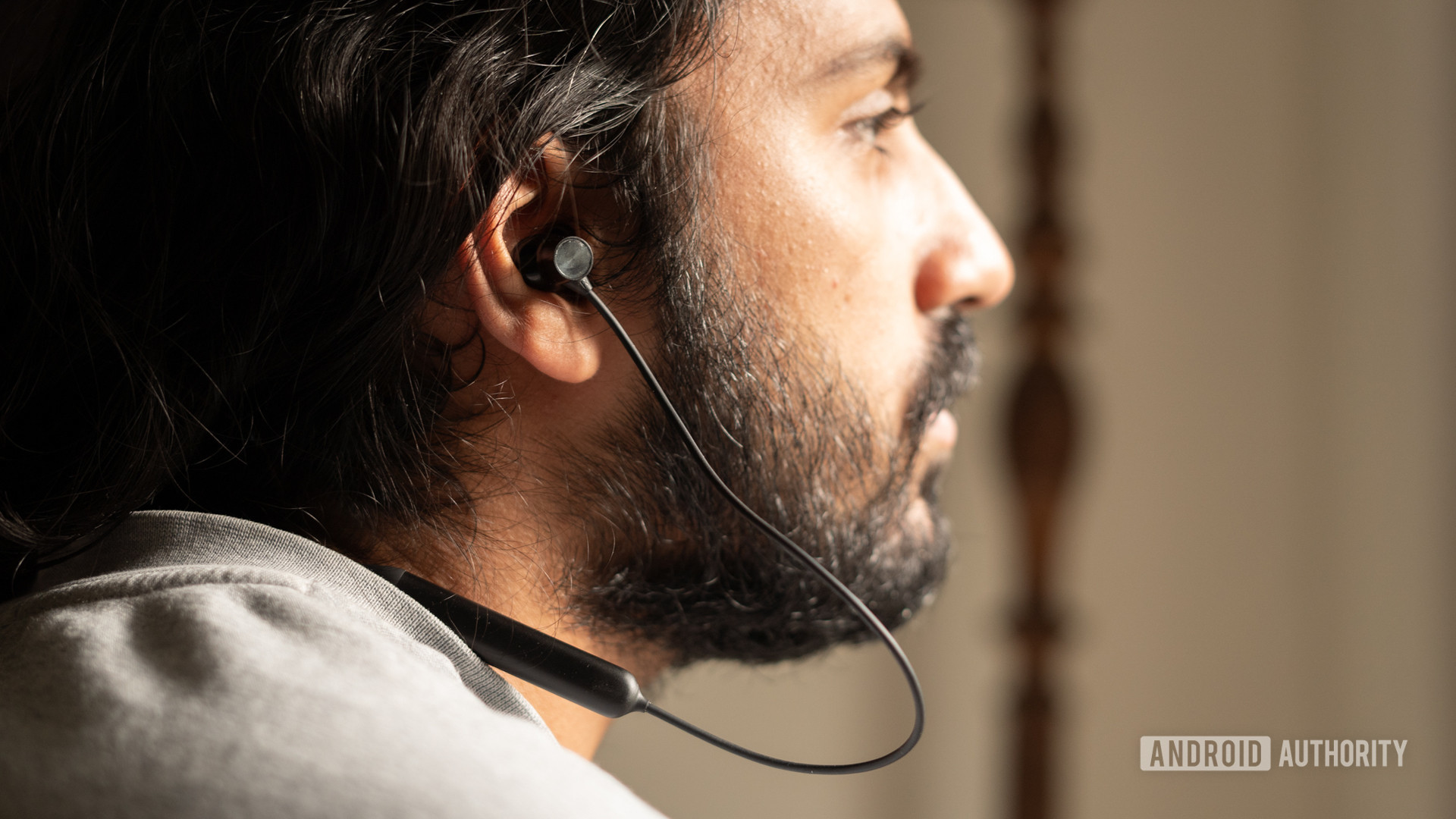 A picture of the OnePlus Bullets Wireless Z in ear worn by a man looking frame-right.