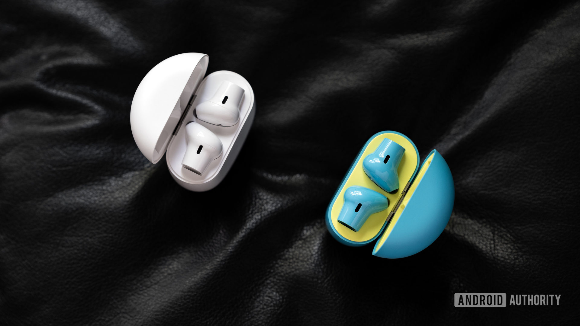 An aerial picture of the OnePlus Buds true wireless earbuds in white and Nord Blue facing each other diagonally with the lids open to reveal the earbuds.