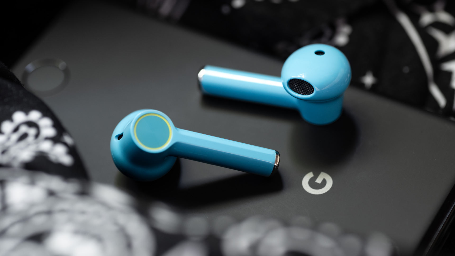 A picture of the OnePlus Buds true wireless earbuds (Nord Blue color) on a Google Pixel 3 smartphone.