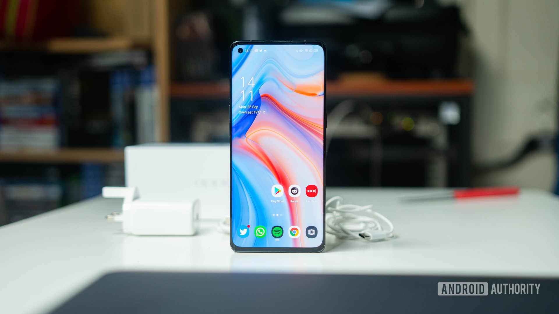 Oppo Reno 4 Pro 5G front on on a desk with the charger