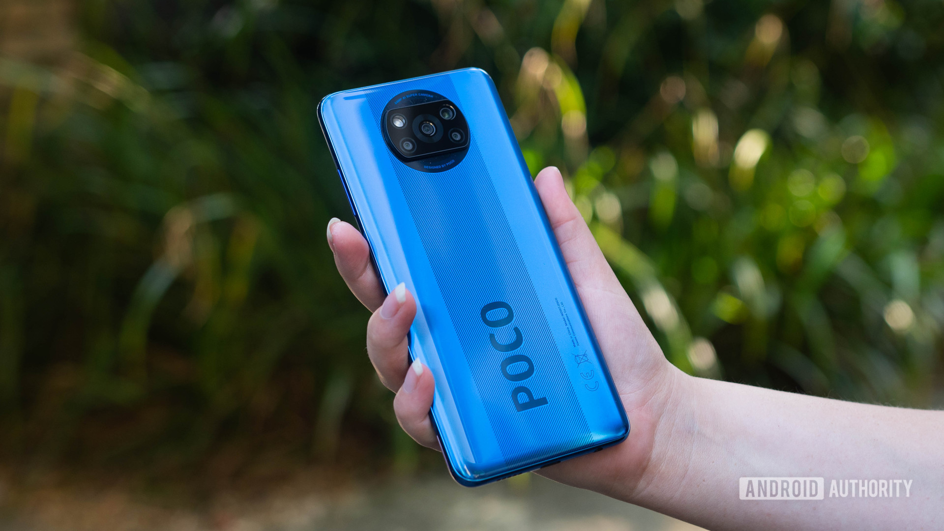 Xiaomi Poco X3 NFC held in the hand outside to show off the rear side