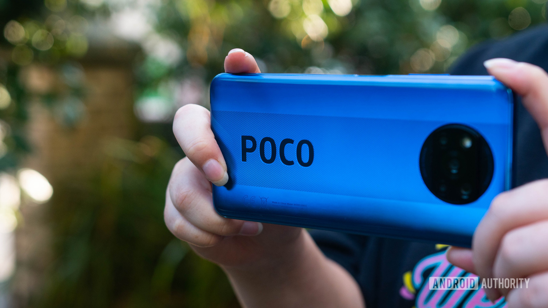 Xiaomi Poco X3 NFC held to take a photo showing off the rear side and POCO branding
