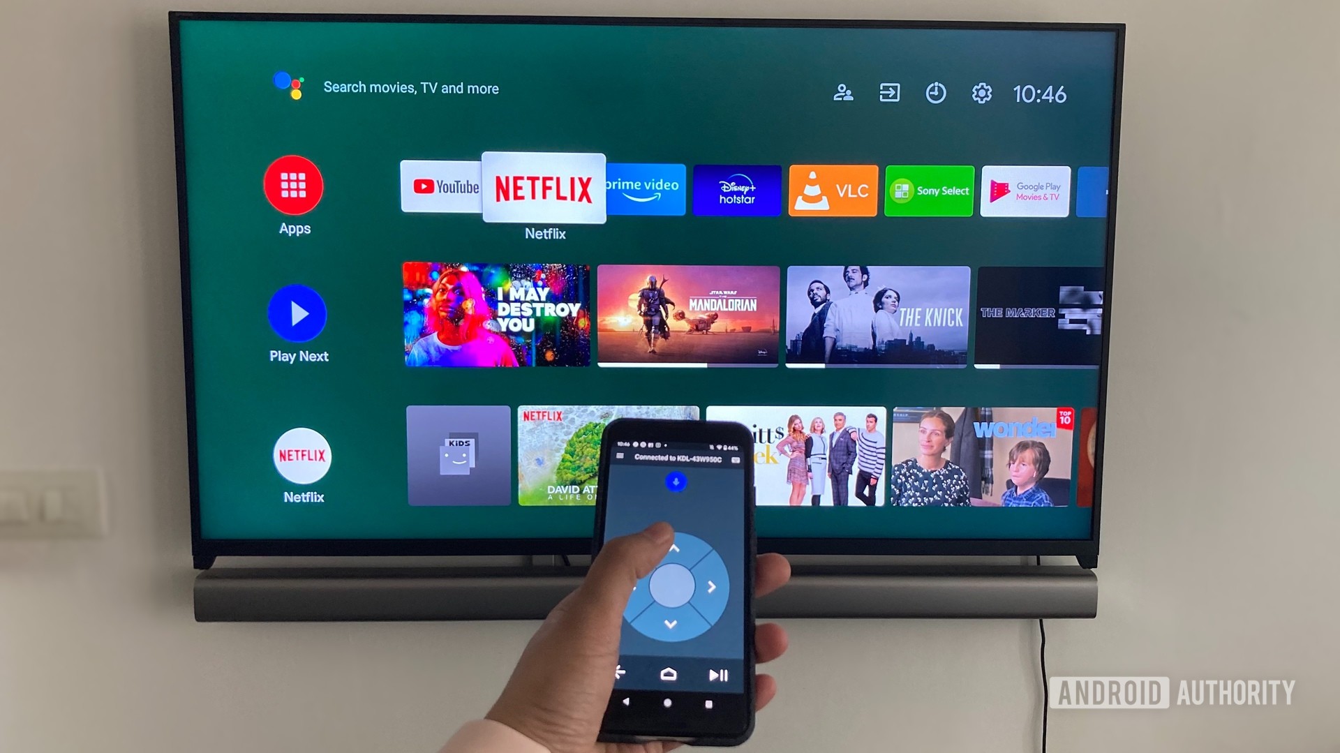 Image montrant l'application de télécommande Android TV sur un smartphone devant un téléviseur Android