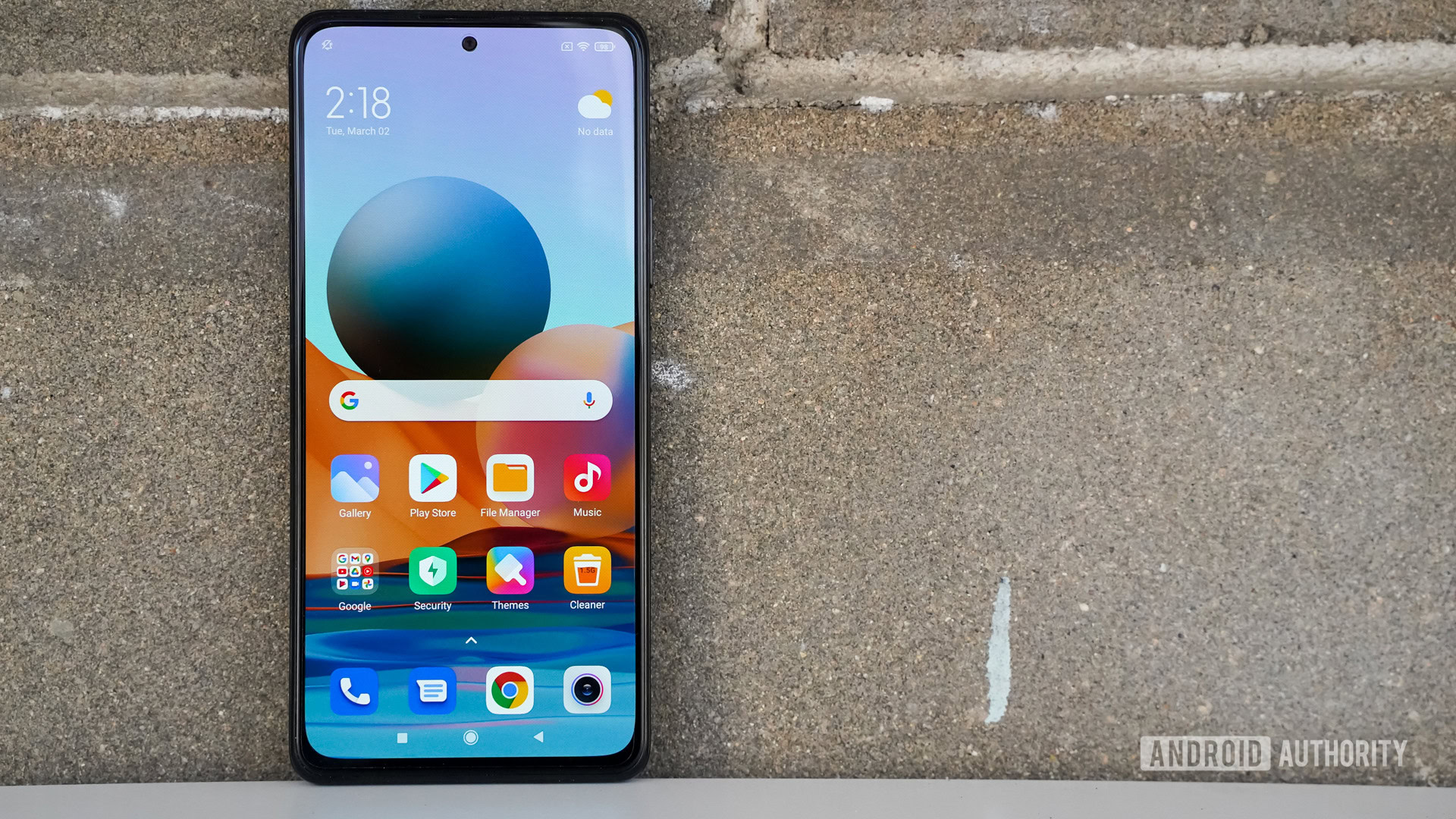 Redmi Note 10 Pro leaning against a brick wall showing the screen.