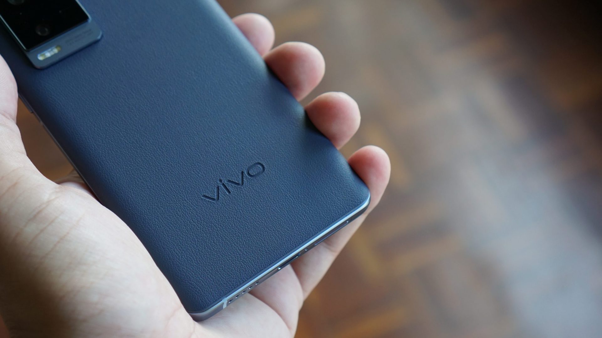 Vivo X60 Pro Plus in hand showing the rear of phone and logo