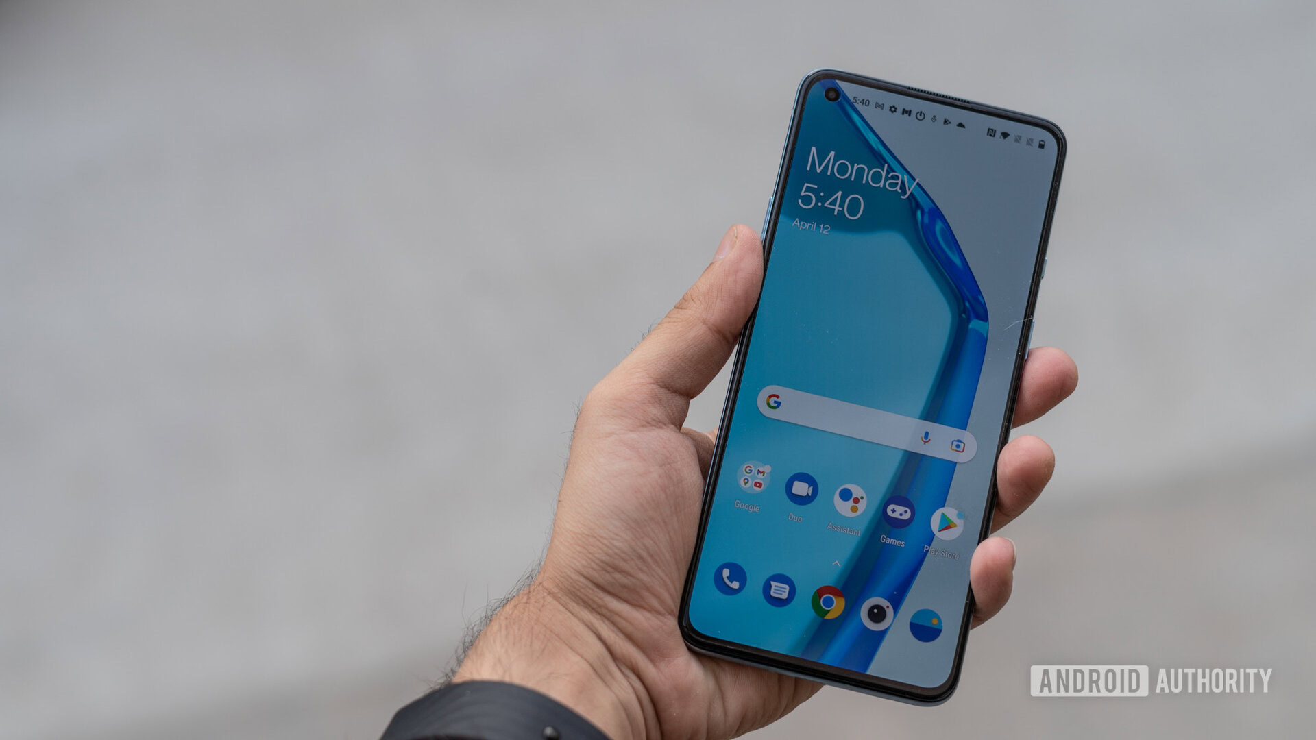 OnePlus 9R review in hand showing display