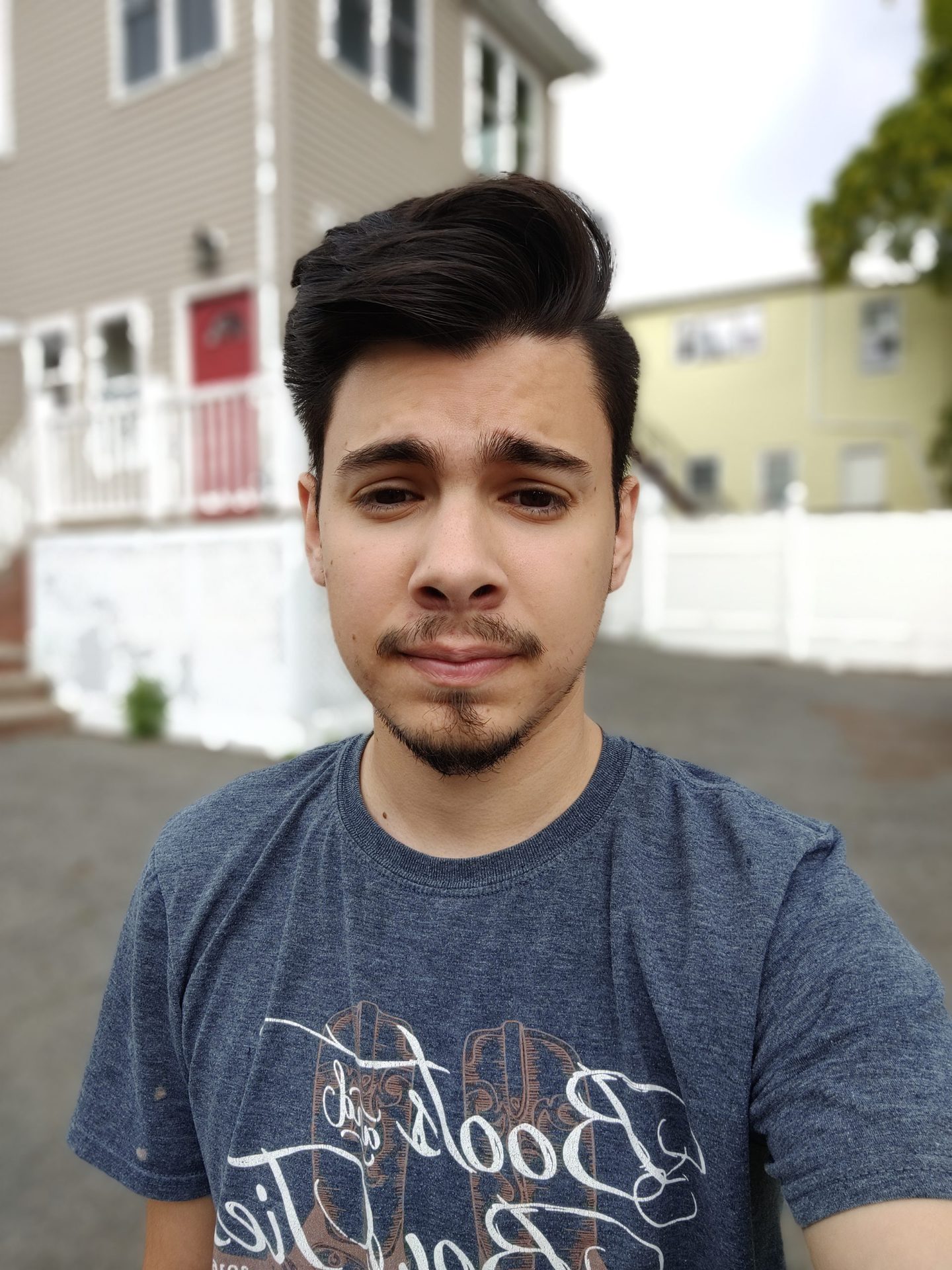 TCL 20 Pro 5G front-facing camera selfie shot of a dark-haired man in a gray t-shirt outdoors.