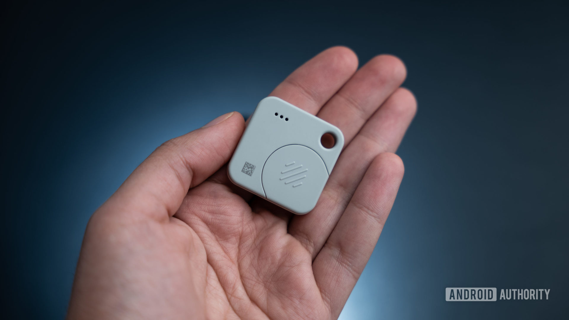 The Tile Mate Tracker rear view in hand showing the battery compartment.