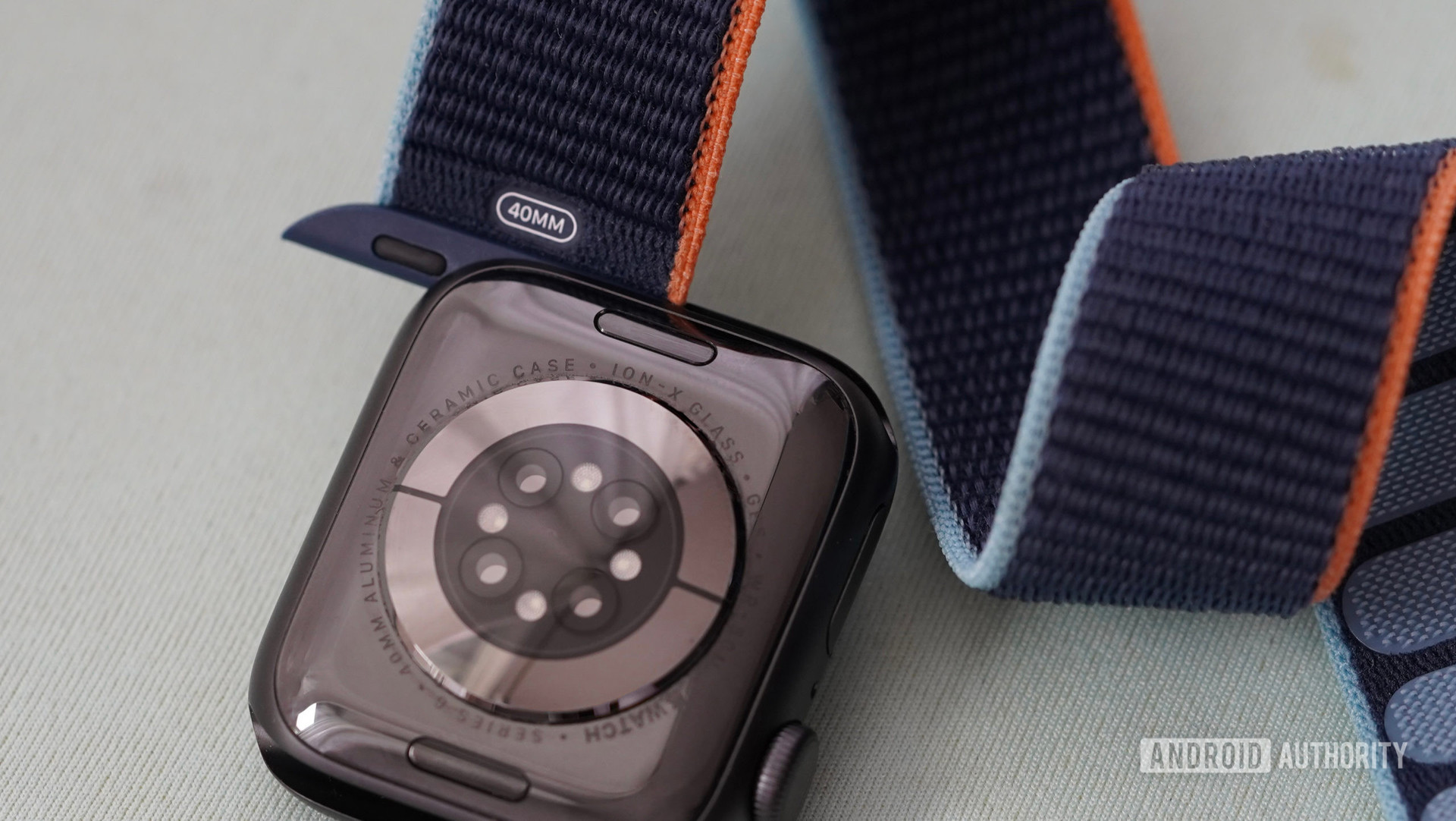 L'Apple Watch Series 6 repose sur une surface bleu clair avec son bracelet en nylon partiellement retiré.