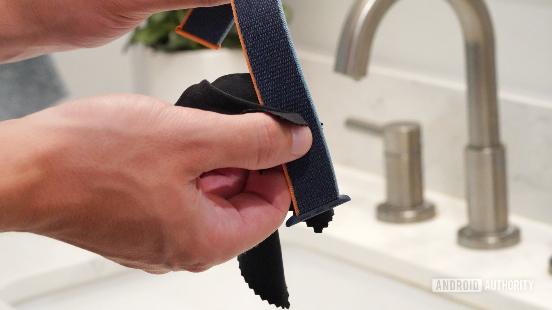 Les mains des hommes nettoient un bracelet Apple Watch en nylon avec un chiffon non abrasif et non pelucheux.