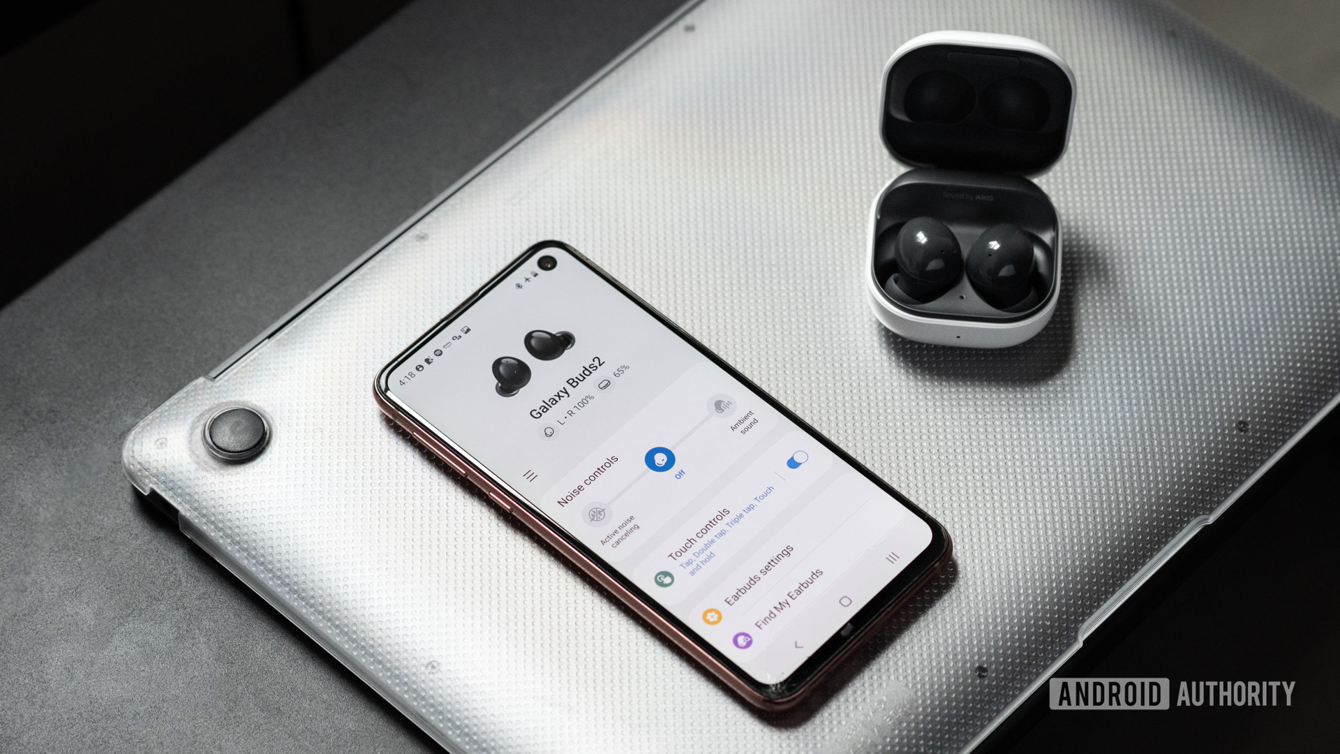 The Samsung Galaxy Buds 2 noise cancelling true wireless earbuds in the open charging case while connected to the Galaxy Wearable app on a Samsung Galaxy S10e.