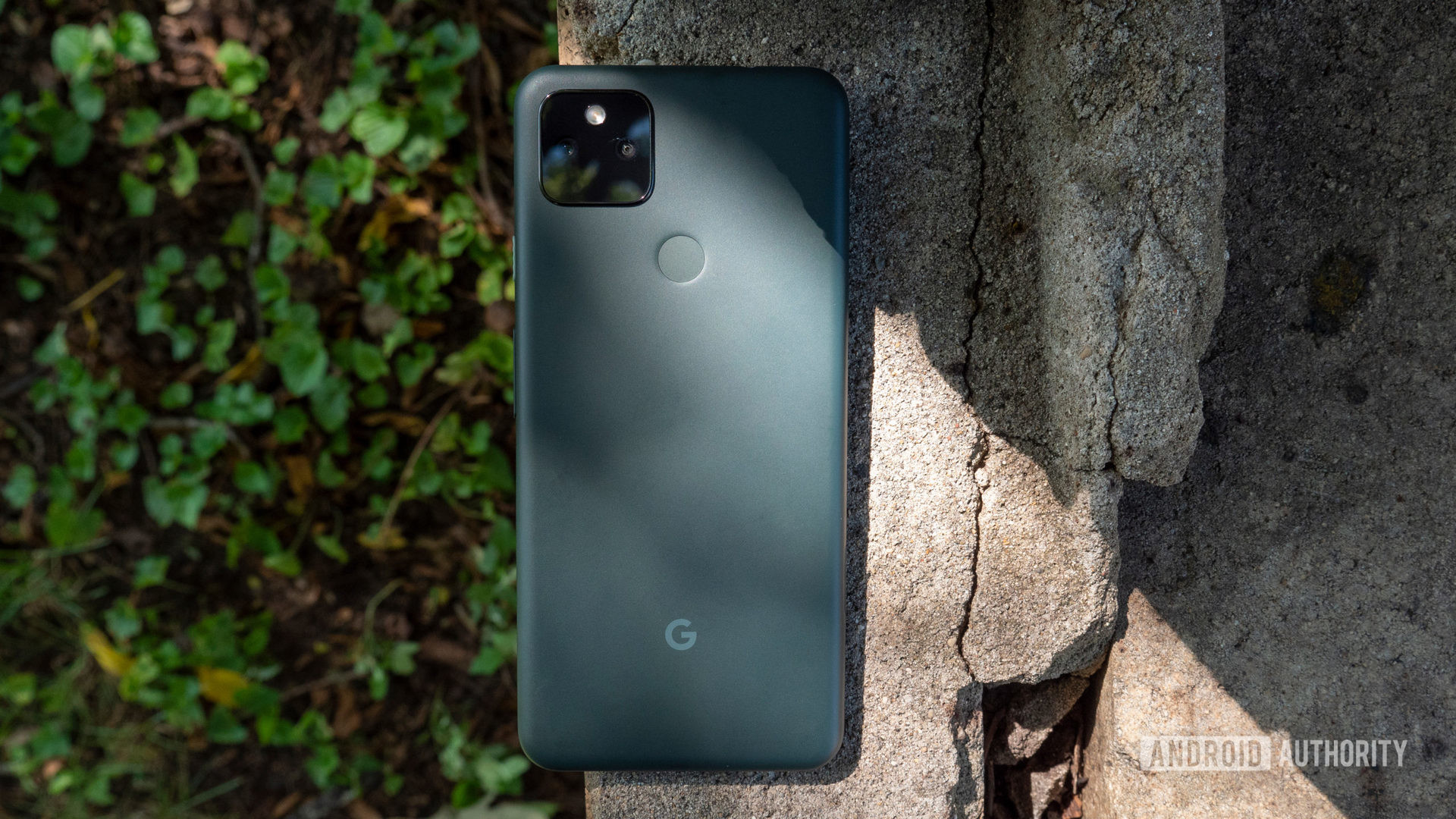 le google pixel 5a sur un morceau de ciment montrant son dos de couleur principalement noire