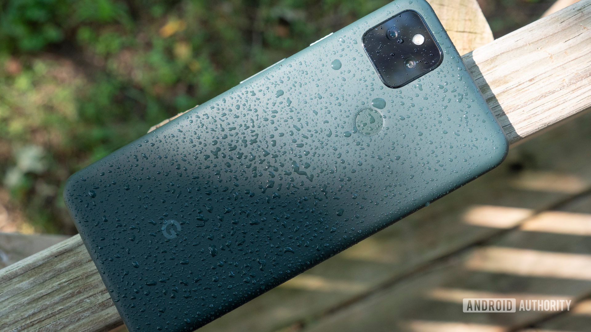 Google Pixel 5a on a bench splashed with water droplets