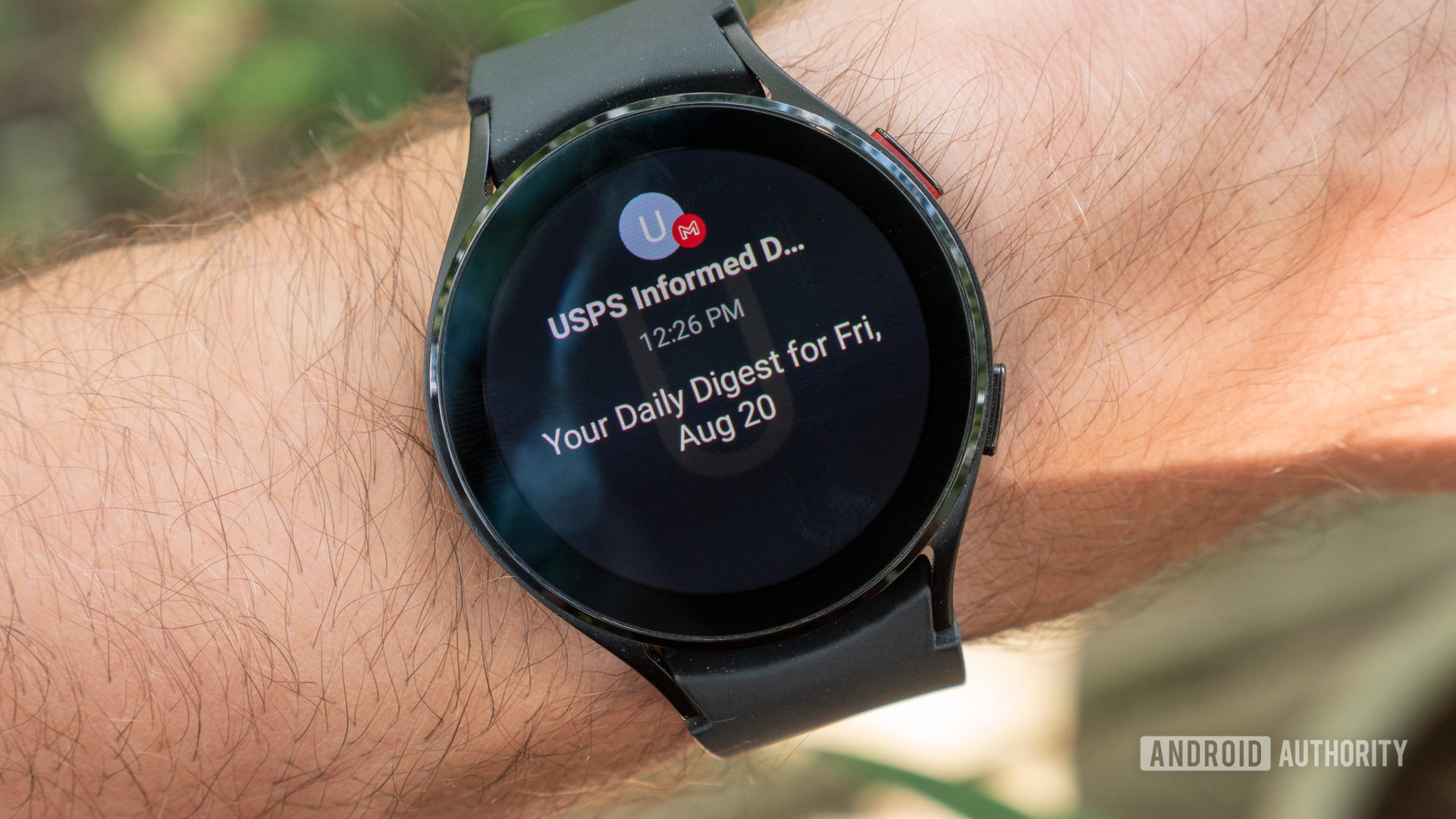 The samsung galaxy watch 4 on a wrist showing the gmail notification
