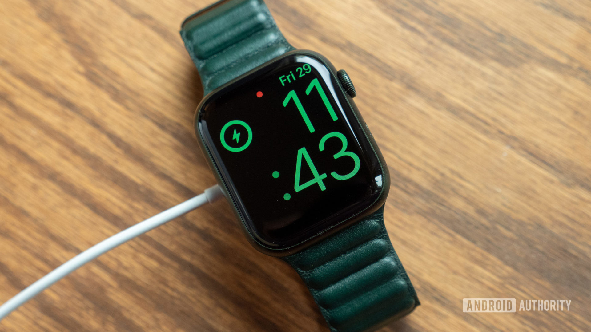 Une image de l'Apple Watch Series 7 sur une table branchée et en charge