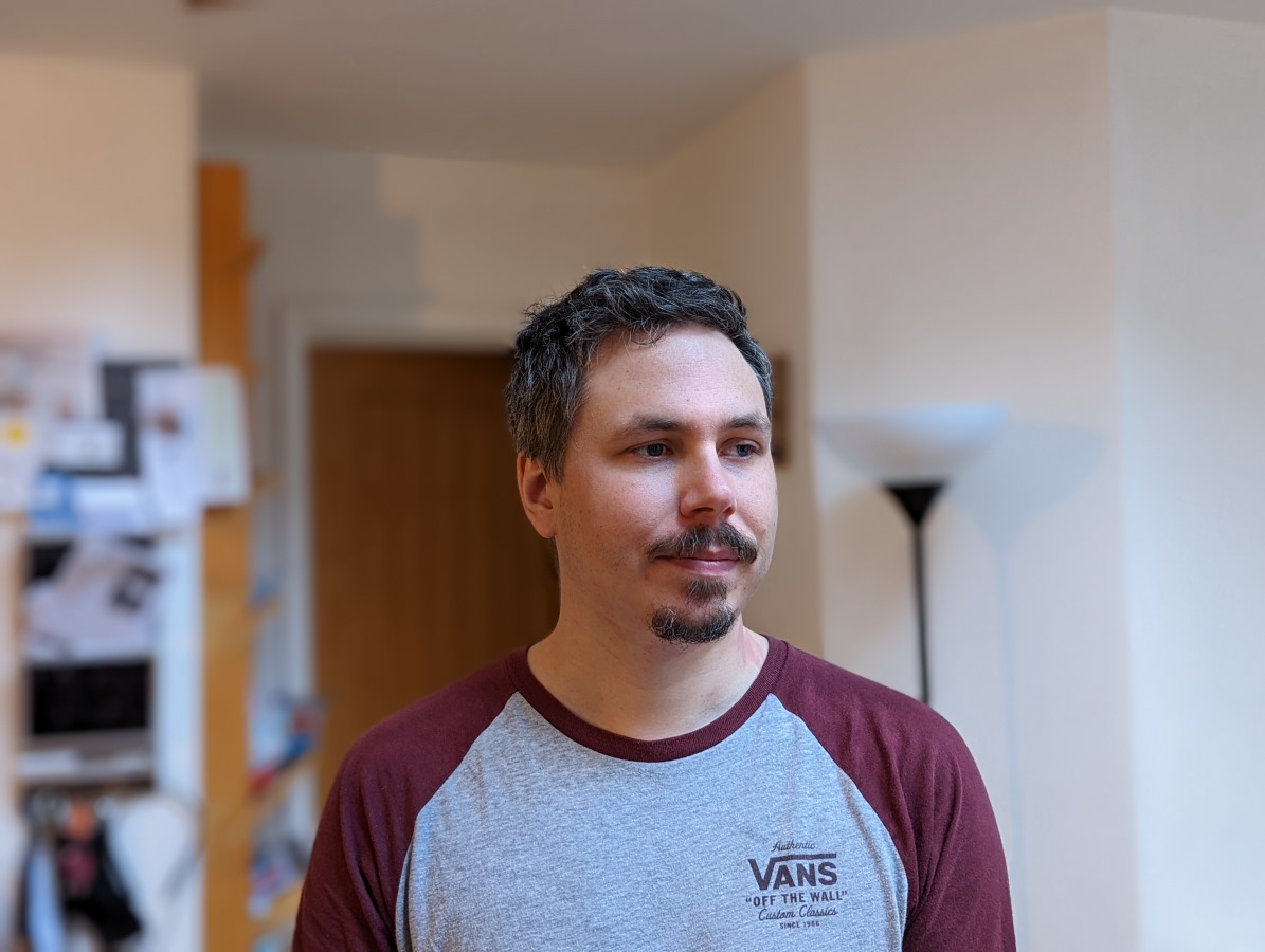 Camera sample portrait of a man with dark hair, wearing a grey and burgundy top, taken on the Google Pixel 6 Pro