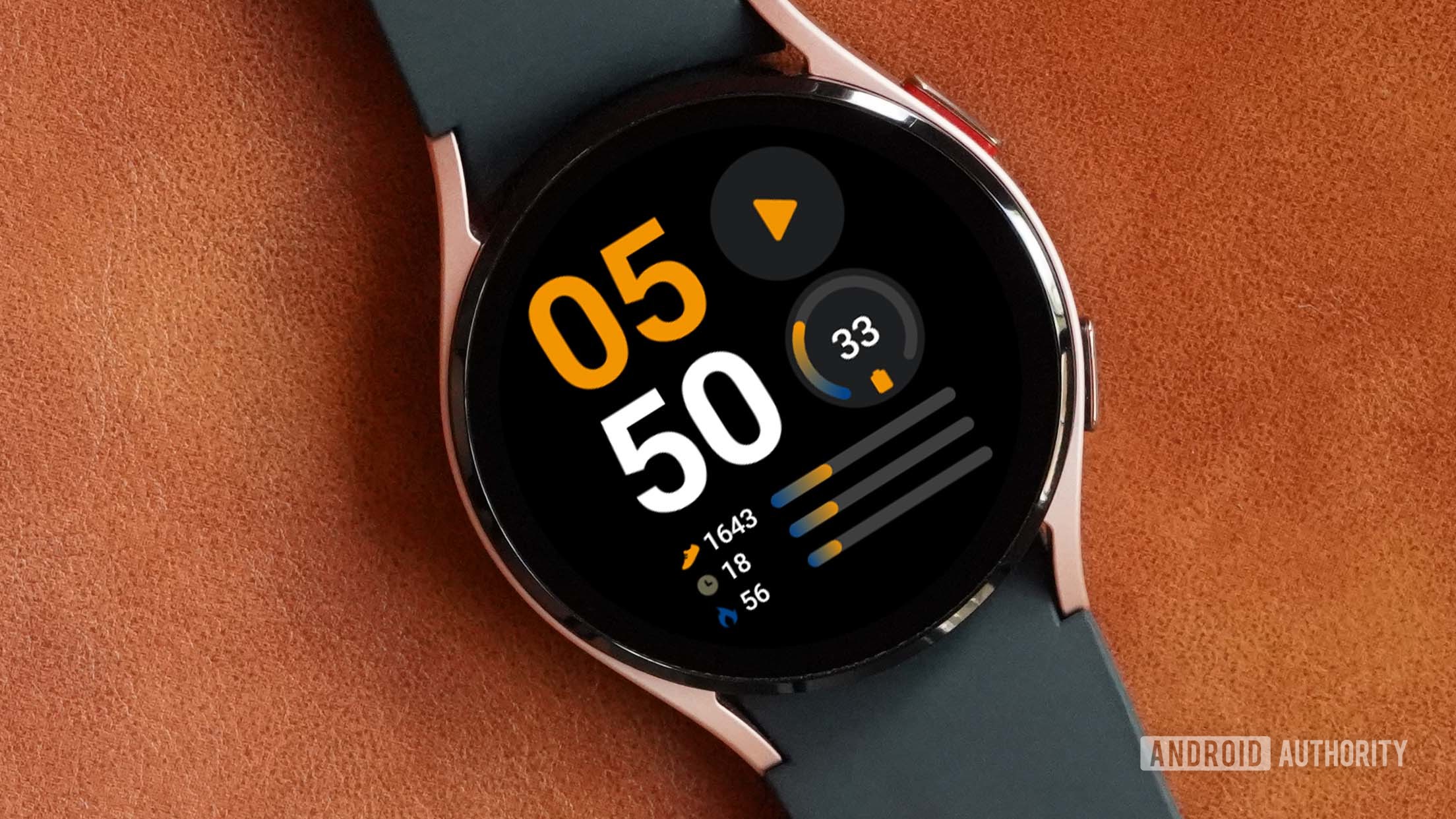 A samsung galaxy watch 4 on a leather surface displays the watch face info brick.