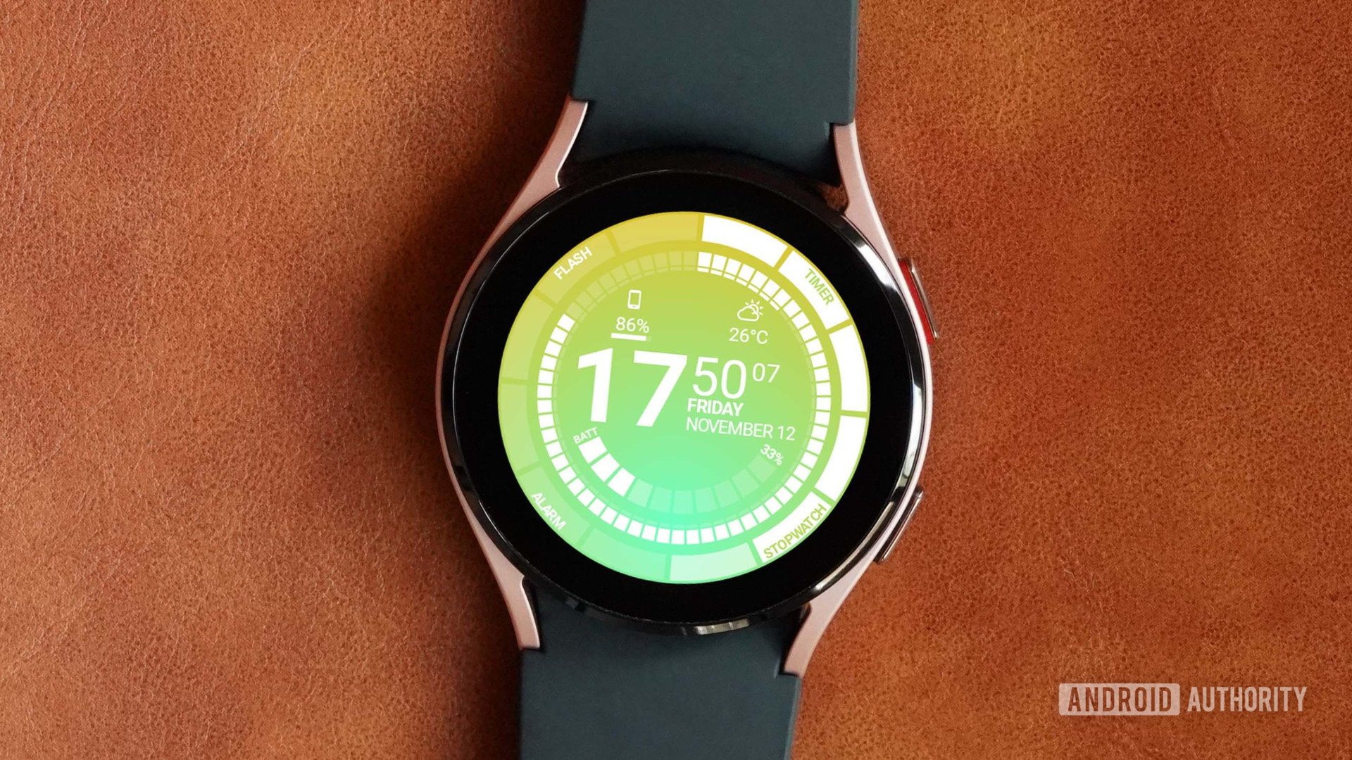 Une Samsung Galaxy Watch 4 repose sur une surface en cuir affichant le cadran de la montre Venom by Thema.