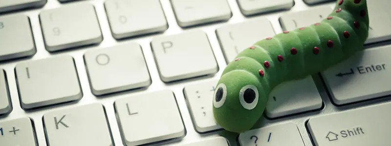 A green worm toy on a white keyboard